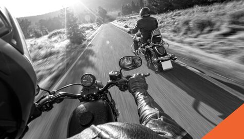 Two friends riding their motorcycles down the road