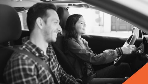 man and woman smiling in their car