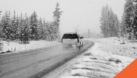 The Ultimate Guide To Winter Driving | suv driving along snowy road with snow covered trees | Billyard Insurance Group blog