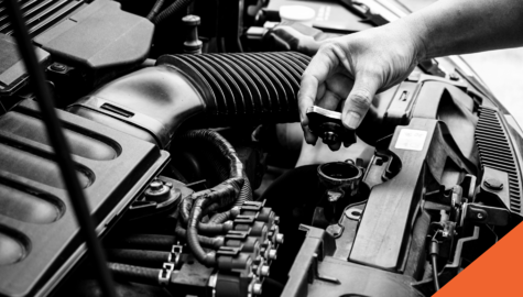 Five maintenance tips to keep your car insurance premiums low | hand holding a car part overtop of an engine | Billyard Insurance Group blog