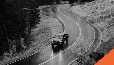 pickup truck driving down winding road