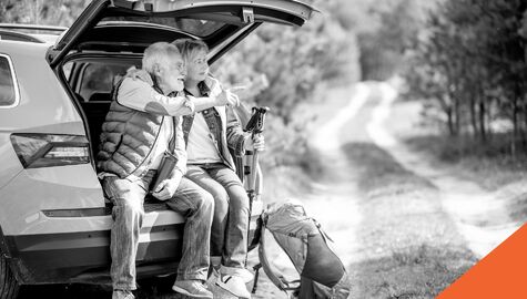 Two seniors sitting on tailgate ready for a hike