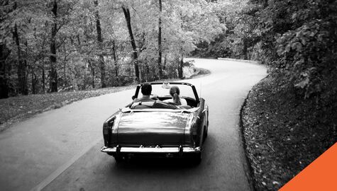 Classic Convertable car driving down winding road