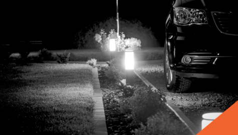 car in driveway at night with lights lining driveway