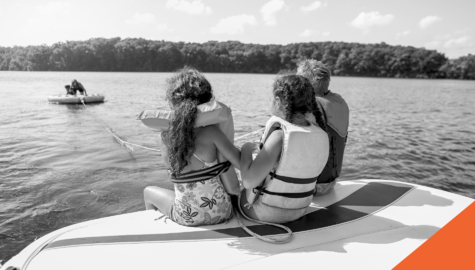 kids on a boat pulling in a tube