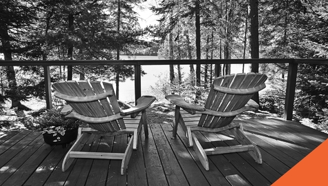 Two Aderondac chairs on the dock of a lake