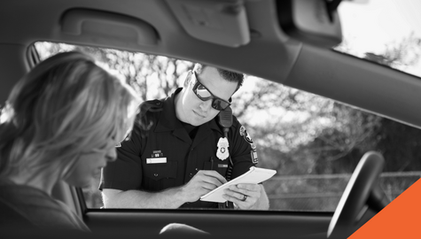 Police officer writing up a driver's parking ticket