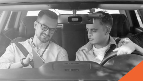 Young driver and examiner looking over a clipboard in a car