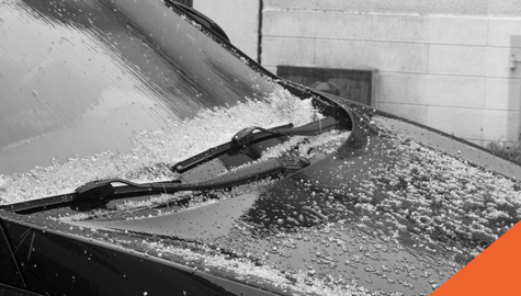 A damaged car windshield and hood frozen over
