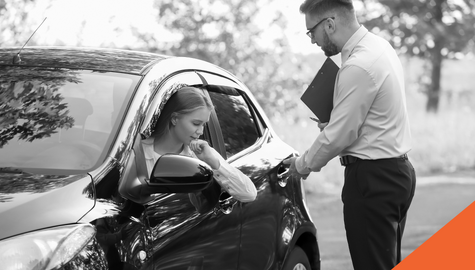 A young driver talking to her driving instructor with a clipboard