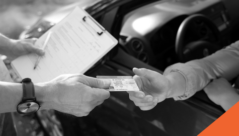 A drivers license being handed to a person